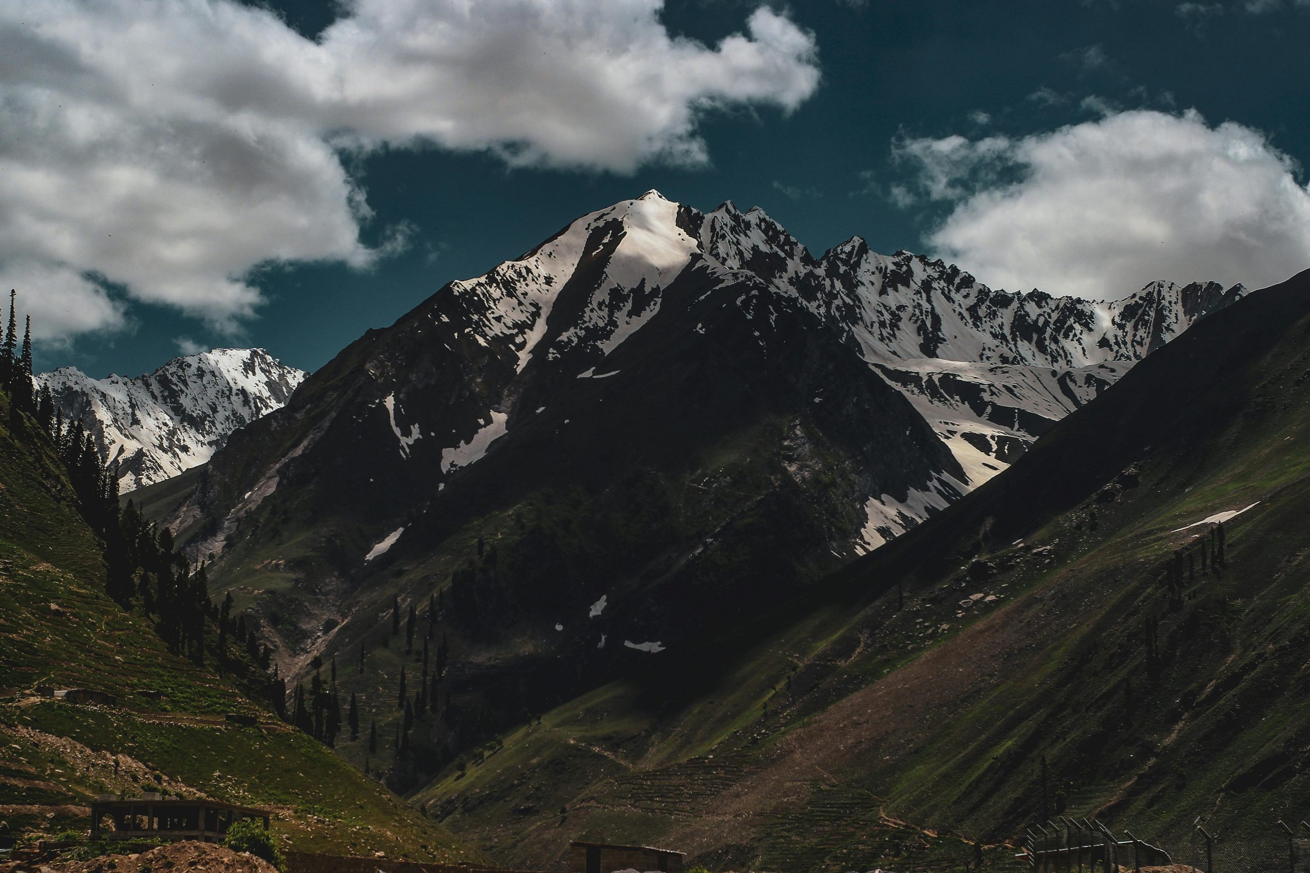 Breathtaking view of the snow-capped mountains in Murree, Pakistan under a bright cloudy sky.